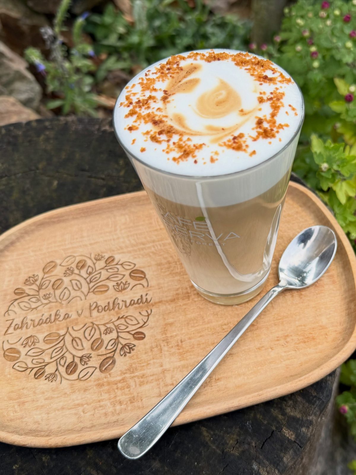 Latte macchiato na dřevěném podnosu s vypáleným logem Zahrádky